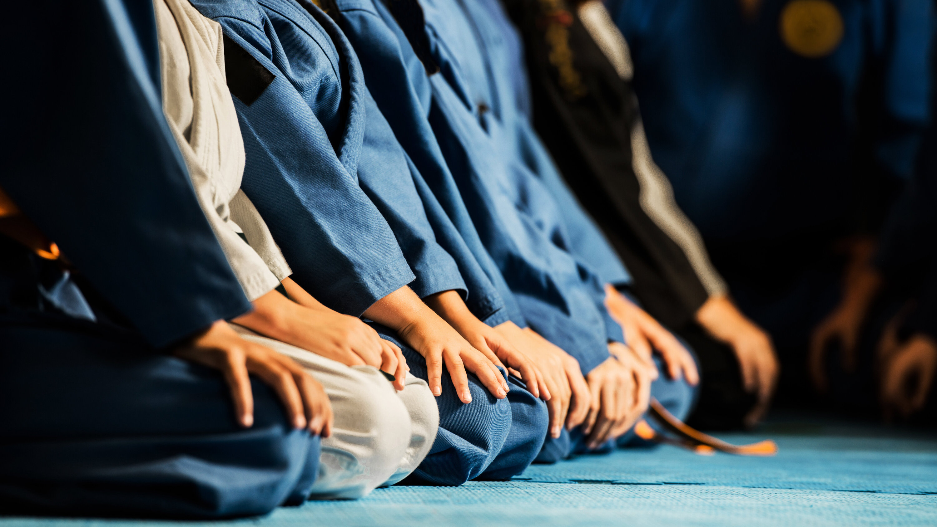 Trainer knien zu Beginn der Stunde auf dem Boden