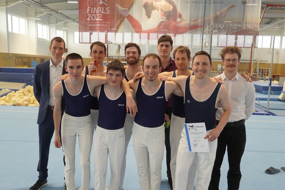 Das Turnteam Elbfelge posiert für ein Gruppenbild beim Liga-Auftakt in Thüringen. Die Turner stehen auf der Bodenfläche.
